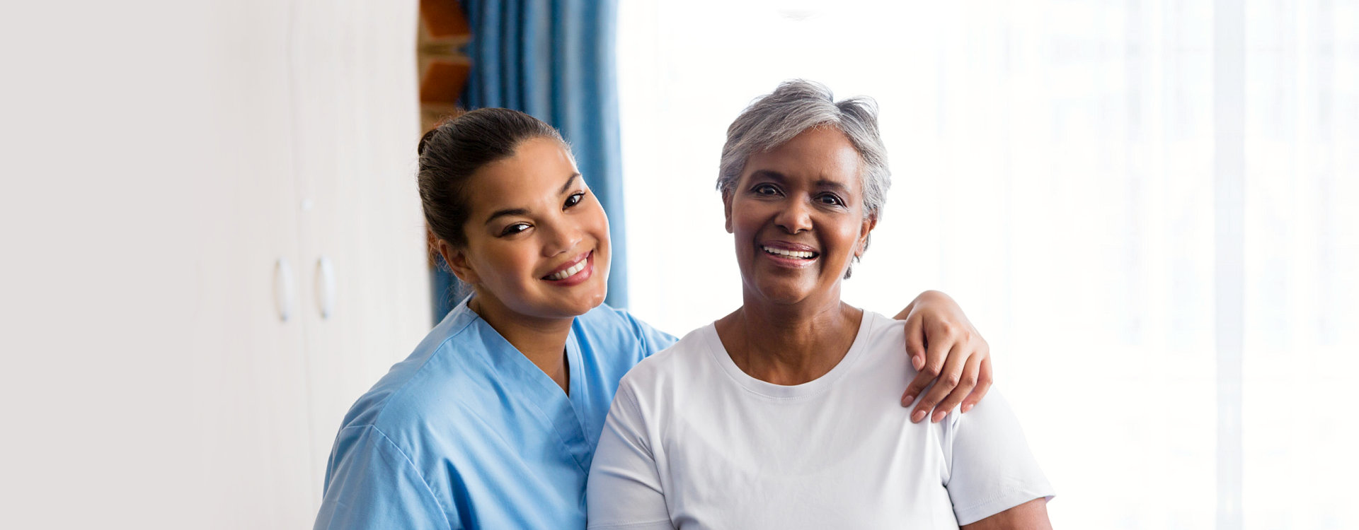 caregiver and senior woman are smiling