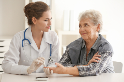 nurse measuring blood sugar level of diabetic patient