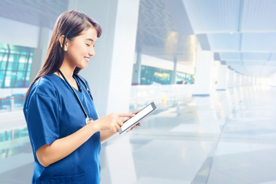 nurse with stethoscope using tablet