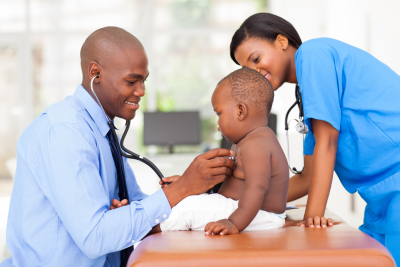 male pediatric doctor examining baby boy with female nurse