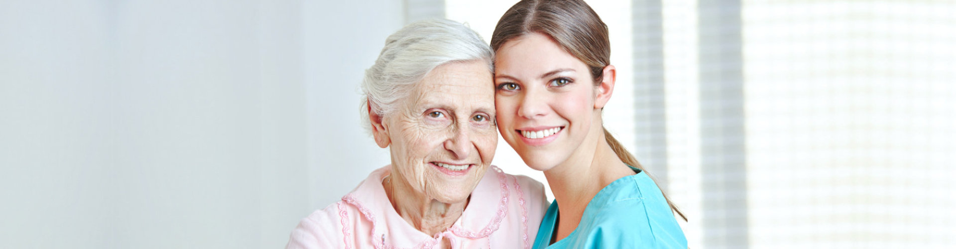 caregive and senior woman are smiling at home