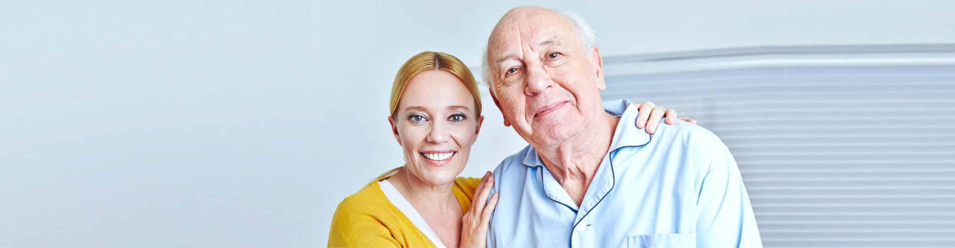 caregiver and senior man are smiling